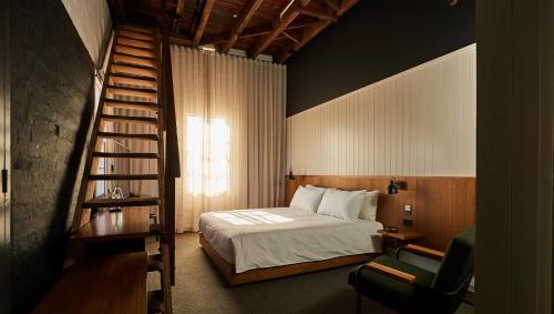 1 dormitorio con 1 cama y escalera de caracol en The Premier Mill Hotel en Katanning