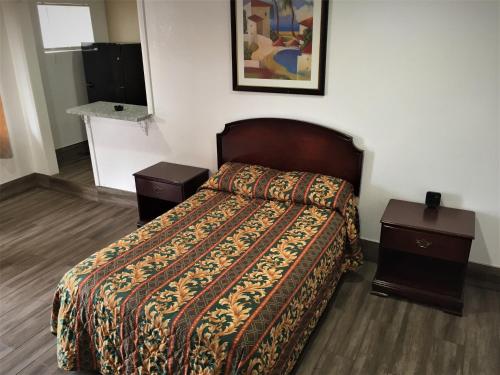 una camera d'albergo con un letto e due comodini di Welcome Inn Motel a Montclair