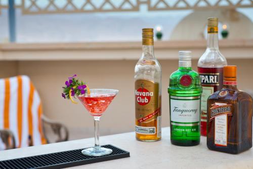 a drink on a table with two bottles of alcohol at Herods Boutique Eilat a Premium collection by Fattal Hotels in Eilat