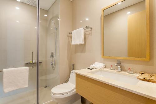 a bathroom with a toilet and a sink and a shower at The Ocean Apartment IDCWH B602 in Danang