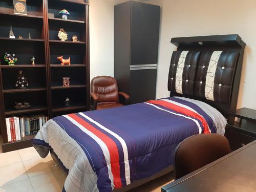 a bedroom with a bed and a chair at Departamento cómodo y completo en Toluca in Toluca