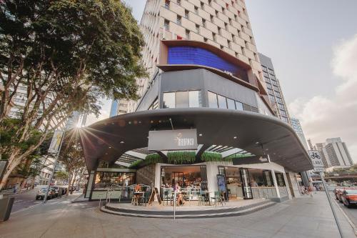 a building on a street with tables and chairs at Pullman Brisbane King George Square in Brisbane