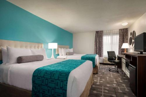 a hotel room with two beds and a television at Howard Johnson by Wyndham Appleton in Appleton