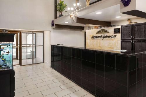 a restaurant with a black counter and a fish tank at Howard Johnson by Wyndham Appleton in Appleton
