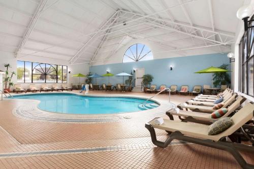 a pool in a hotel room with lounge chairs at Wyndham Garden at Niagara Falls in Niagara Falls