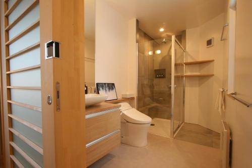 een badkamer met een douche, een toilet en een wastafel bij ASANOHA in Furano