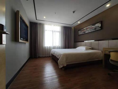 Habitación de hotel con cama y ventana en 7Days Dongguan Tangxiayin Square Walmart, en Dongguan