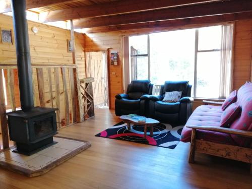 a living room with a couch and a stove at Minnow cabins Lower Beulah in Sheffield