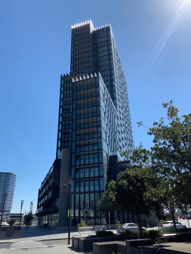 a tall glass building with a lot of windows at Melbourne Private Apartments - Collins Wharf Waterfront, Docklands in Melbourne