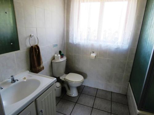a bathroom with a toilet and a sink at Palm Beach Chalets in Port Edward