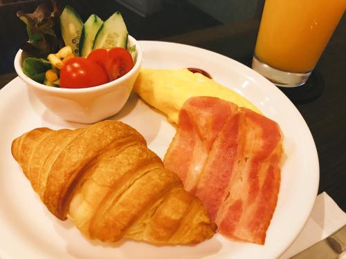 a plate with croissants and a salad and a bowl of fruit at Hotel Patio Ise (Adult Only) in Ise