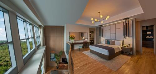 a bedroom with a bed and a desk and windows at Somerset Maslak Istanbul in Istanbul