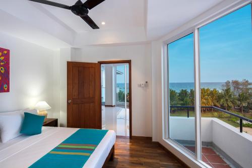 尼拉瓦利的住宿－CASAMIA Oceanfront Condos Nilaveli，一间卧室配有一张床,享有海景