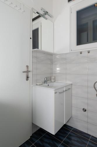 a white bathroom with a sink and a window at Apartment Nana in Piran
