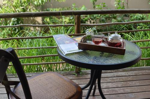 uma mesa com dois copos de vinho numa varanda em Acacia Inn GuestHouse em Maputo