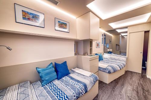 twee bedden in een kamer met blauwe kussens bij La Casetta di Portofino by PortofinoVip in Portofino