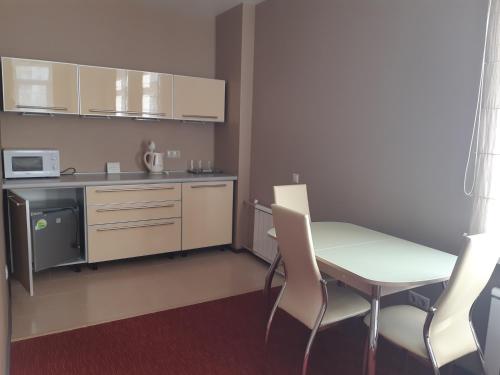 una pequeña cocina con mesa y sillas en una habitación en Hotel 55 Shirota en Novosibirsk