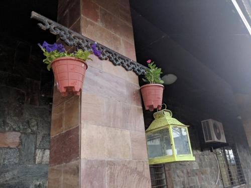 a building with two flower pots on a wall at Ivy Orchids Villa - Lonavala in Lonavala