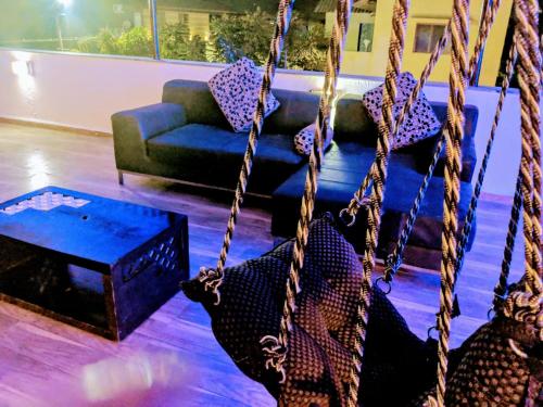 a swing in a living room with a couch at Ivy Orchids Villa - Lonavala in Lonavala