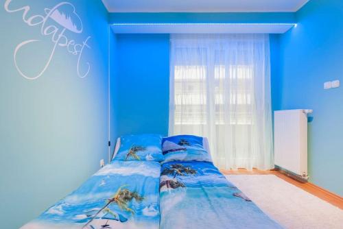 Un dormitorio con paredes azules y una cama con arañas. en AquaFlat, en Budapest