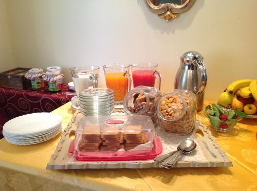 una mesa con una bandeja de comida y vasos de zumo en B&B La Dimora, en Sulmona