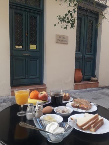 una mesa con platos de comida y bebidas. en Polyxenia Hotel, en Nauplia