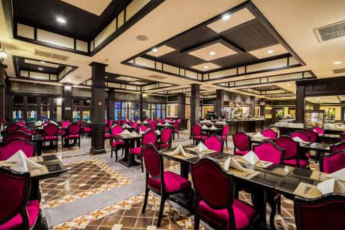 a dining room with pink chairs and tables at Wora Bura Hua Hin Resort & Spa in Hua Hin