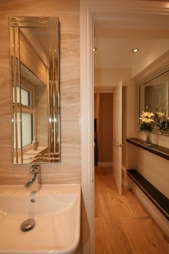 a bathroom with a sink and a mirror at The Thomas Suite in Llandudno