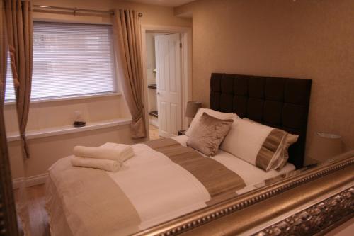a bedroom with a large bed and a window at The Thomas Suite in Llandudno
