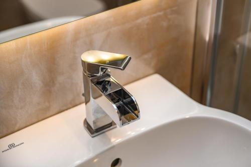 a chrome bathroom sink faucet on top of a toilet at Luxury Suite Sirmione in Sirmione