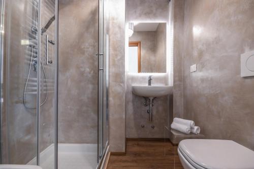 a bathroom with a shower and a toilet and a sink at Luxury Suite Sirmione in Sirmione