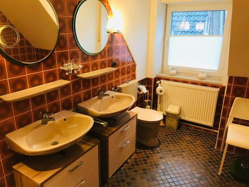 a bathroom with two sinks and a toilet at Schrapper in Grönheim