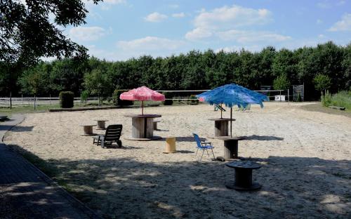 two umbrellas and chairs sitting in the sand at Ferienresort Texas MV in Kirch Jesar