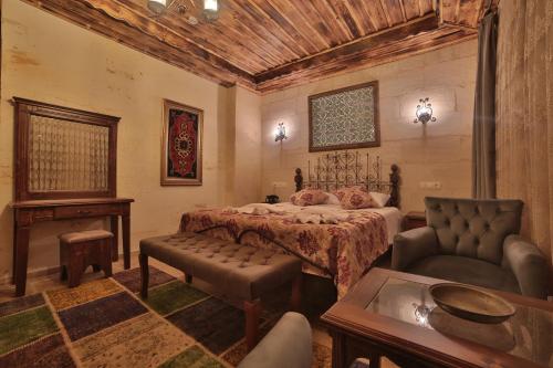 a bedroom with a bed and a couch and a table at Caravanserai Inn Hotel in Goreme
