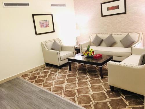 Sala de estar con 2 sofás y mesa de centro en Ramada by Wyndham Dammam Khaleej Road, en Dammam