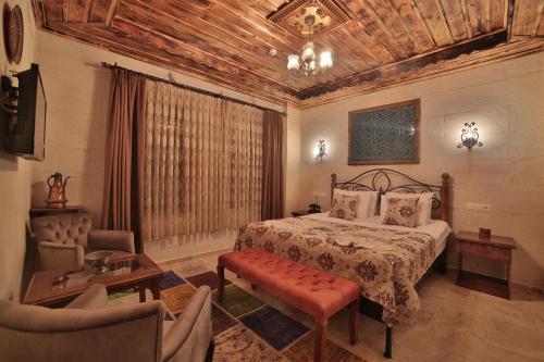 a bedroom with a bed and a couch and a chair at Caravanserai Inn Hotel in Goreme
