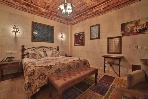 a bedroom with a bed and a bench in it at Caravanserai Inn Hotel in Goreme
