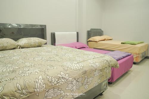 um quarto com duas camas num quarto em M Stay Guest House Jogja em Yogyakarta