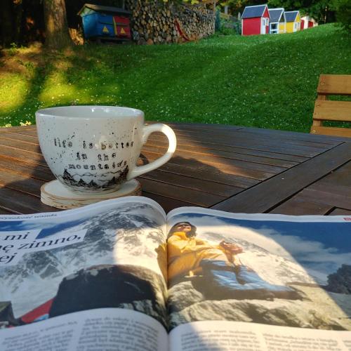 a book on a table with a cup and a coffee mug at Leśne Apartamenty in Zieleniec