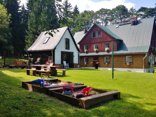a house with a toy sandbox in the yard at Leśne Apartamenty in Zieleniec