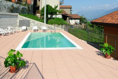 a swimming pool on a patio next to a house at Residence Le Azalee & SPA in Vercana