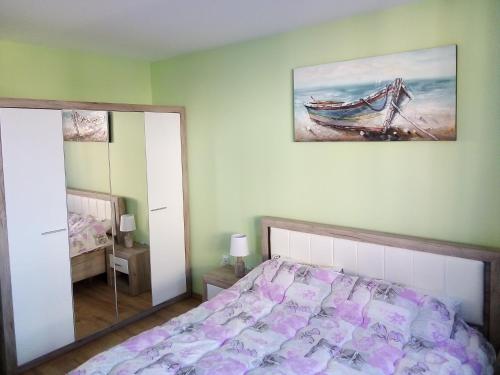 um quarto com uma cama e um quadro na parede em Tvardica Apartment em Burgas