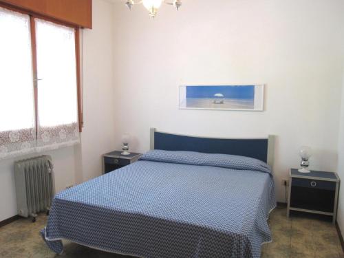 a bedroom with a blue bed and two night stands at Appartamento Franco in Grado