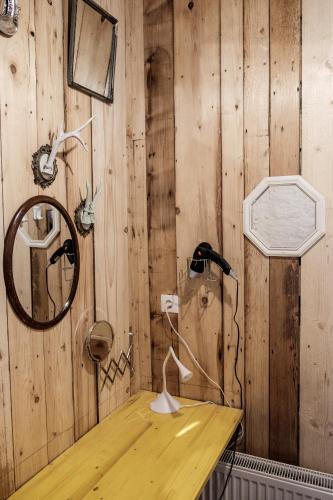a wooden wall with a mirror and a lamp on a desk at Central Cluj Apartments in Cluj-Napoca