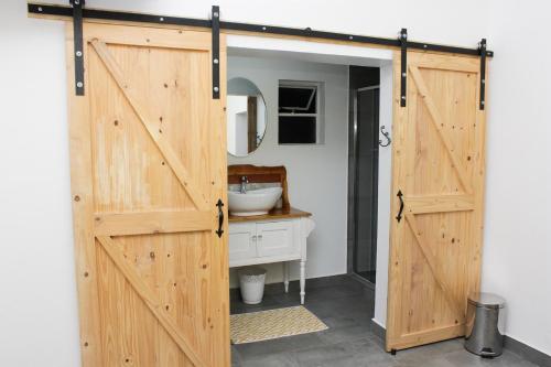 a sliding barn door in a bathroom with a sink at A Touch of Grace in Potchefstroom