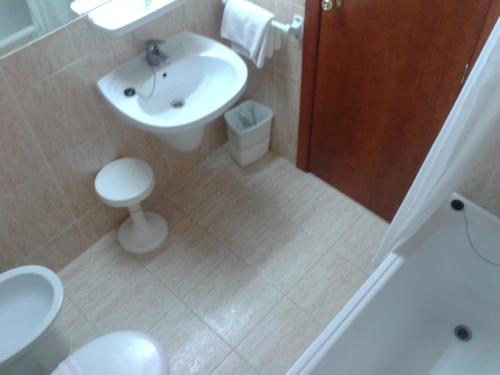 a white bathroom with a sink and a toilet at Hotel Lido in Benidorm