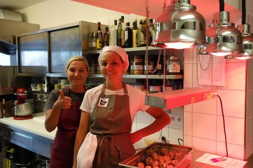two women in a kitchen preparing food in a kitchen at Hotel Bergland in Sillian