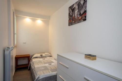 Dormitorio pequeño con cama y vestidor en Alex's House Fregene, en Fregene