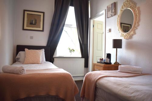 a bedroom with two beds and a window at Whitburn House Hotel in Preston
