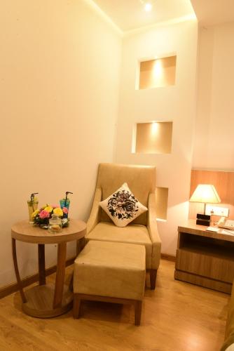 a living room with a chair and a table at SureStay Plus by Best Western Amritsar in Amritsar